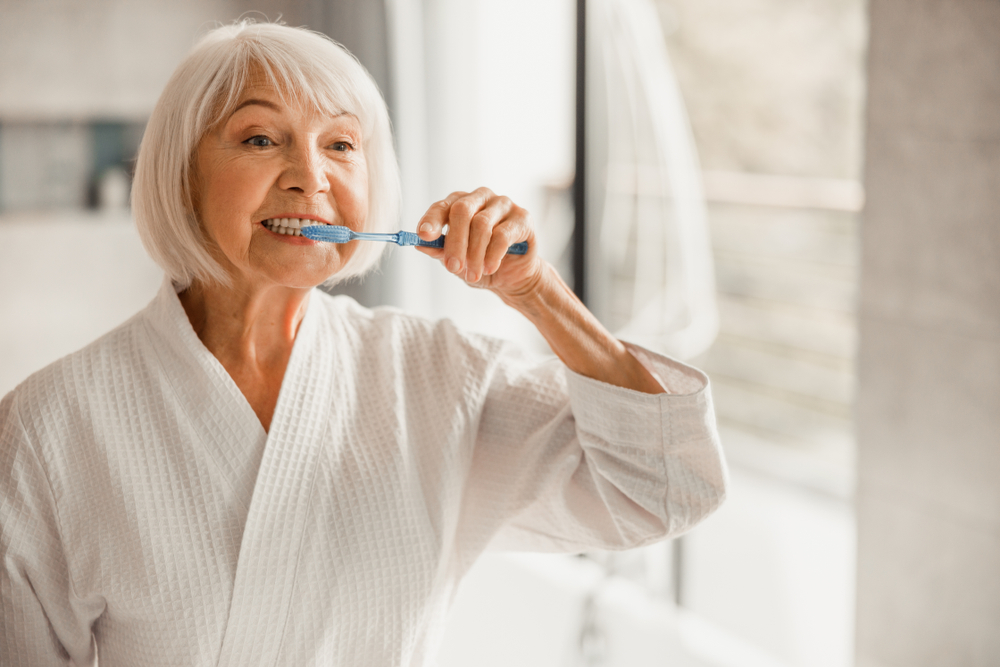 LovelyOldLadyCleaningTeethWithToothbrushStockPhoto - welltica.dk - Vejen til et bedre liv