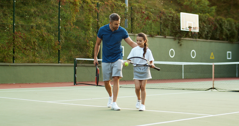 CaucasianHappyHandsomeFatherWithDaughterWalkingAwayFromSport - welltica.dk - Vejen til et bedre liv