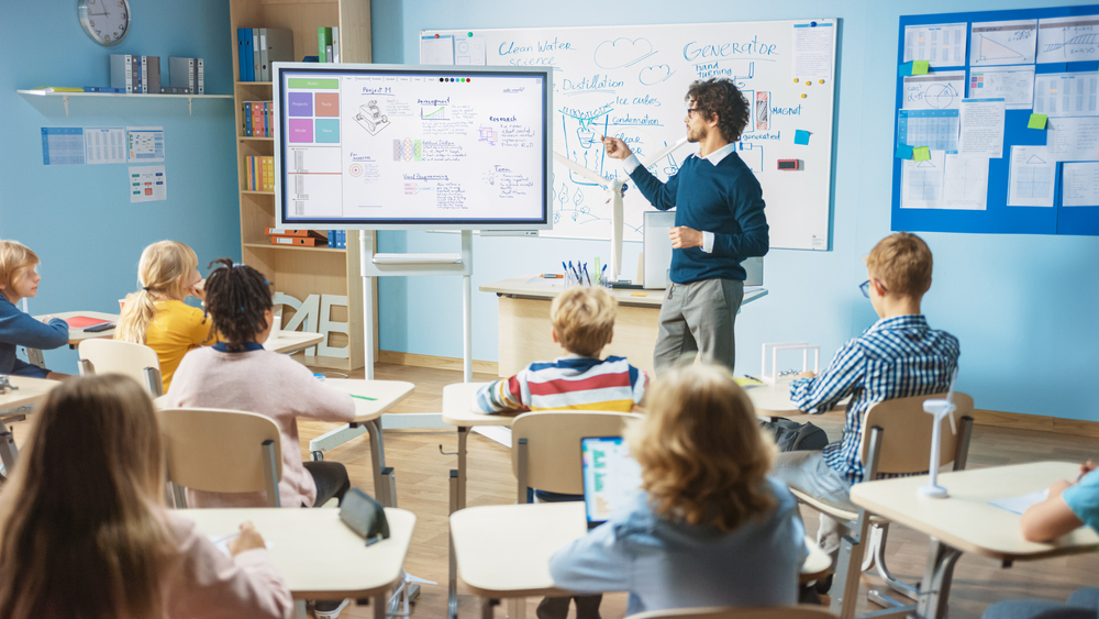 ElementarySchoolScienceTeacherUsesInteractiveDigitalWhiteboardToShow - welltica.dk - Vejen til et bedre liv