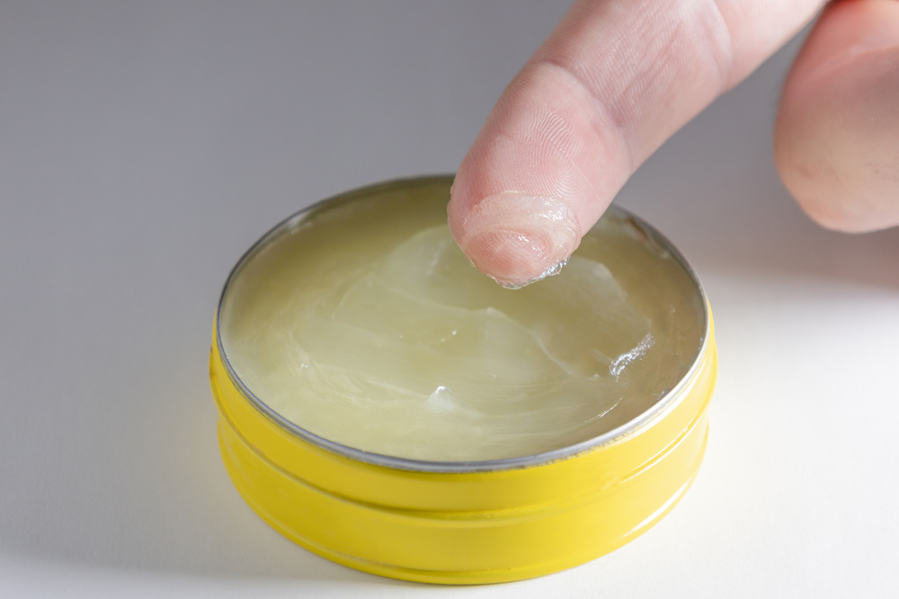 FingerInSmallYellowJarOfVaselineWithWhiteBackground - welltica.dk - Vejen til et bedre liv