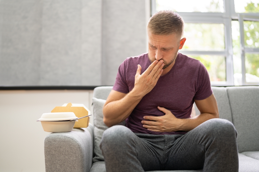 UnhealthyFastfoodStomachHeartburnPersonAfterEatingFood - welltica.dk - Vejen til et bedre liv