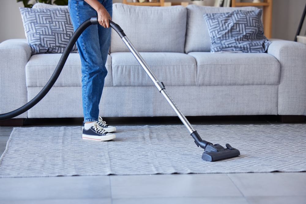 WomanVaccumAndCleaningLivingRoomFloorOrCarpetFor - welltica.dk - Vejen til et bedre liv