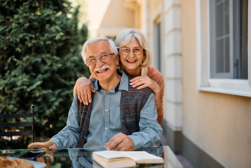 HappySeniorCoupleAtIndependentLivingCommunityLookingAtCamera - welltica.dk - Vejen til et bedre liv