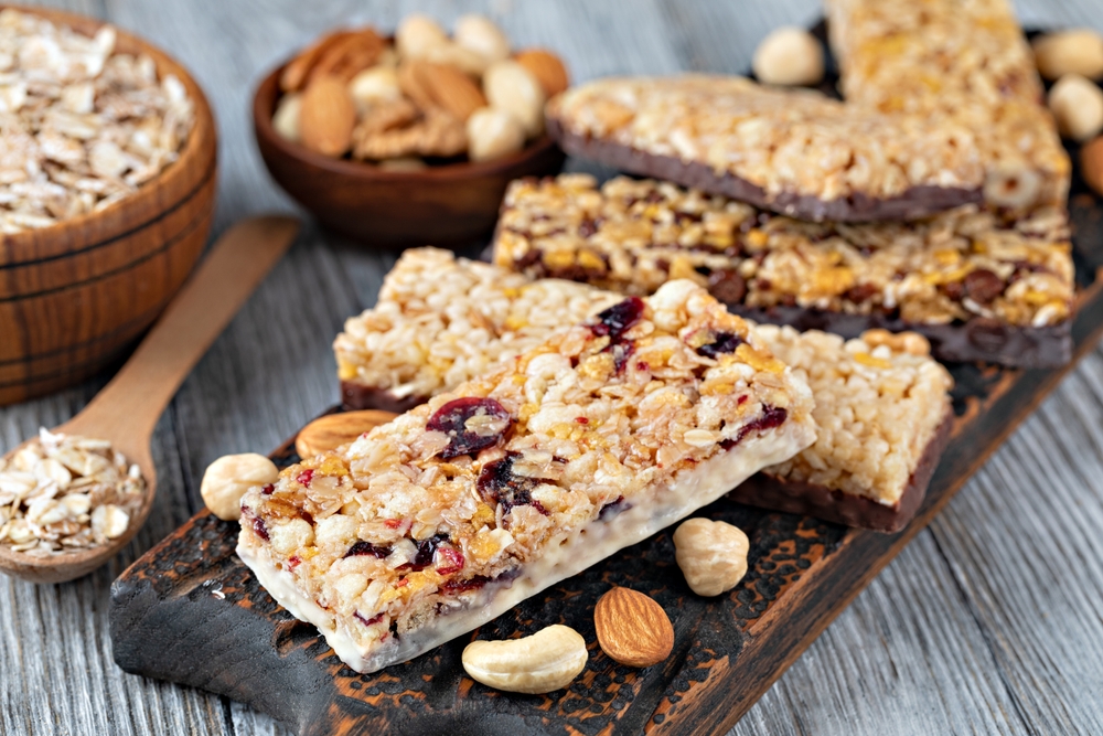 GranolaBarsWithNutsAndDriedFruitsOnWoodenBackground - welltica.dk - Vejen til et bedre liv