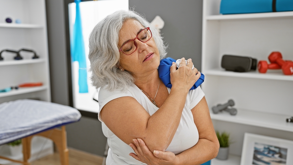 MatureWomanInClinicHoldingIcePackOnShoulderIn - welltica.dk - Vejen til et bedre liv
