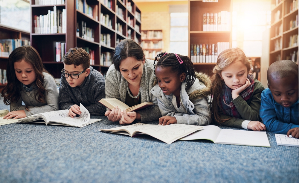 ChildrenEducationAndTeacherWithBooksOnLibraryFloorFor - welltica.dk - Vejen til et bedre liv