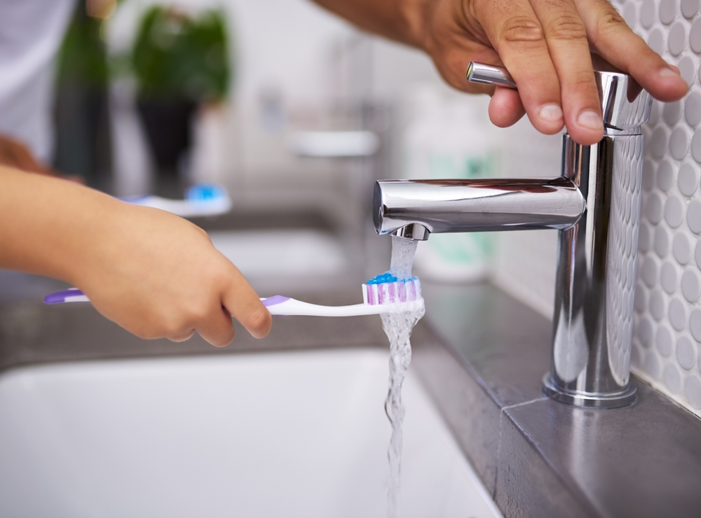 BathroomWaterAndHandsOfChildWithToothbrushForDental - welltica.dk - Vejen til et bedre liv