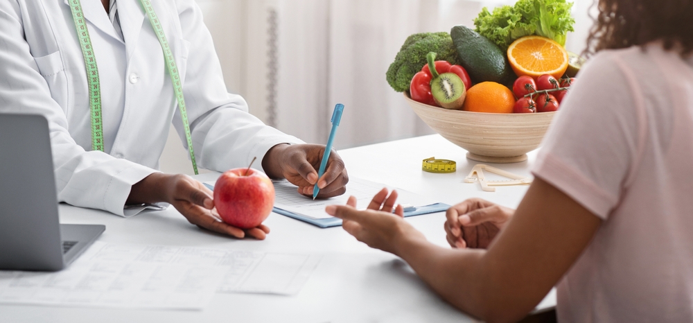 DieticianAfricanWomanGivingYoungPatientHealthyDietTipsHolding - welltica.dk - Vejen til et bedre liv