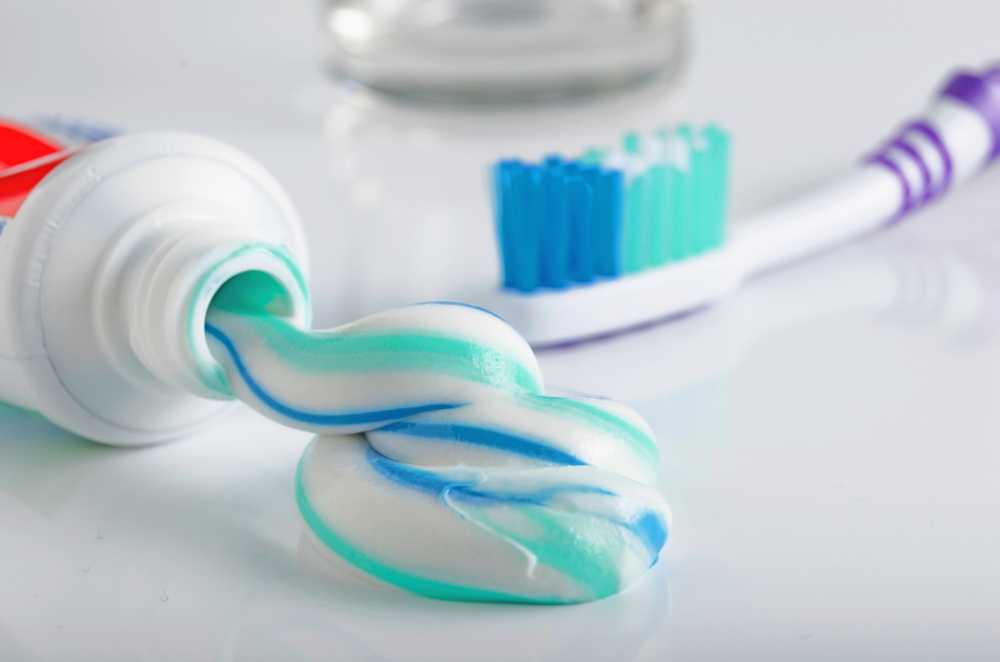 ToothbrushTubeOfToothpasteAndAGlassOnAWhite - welltica.dk - Vejen til et bedre liv