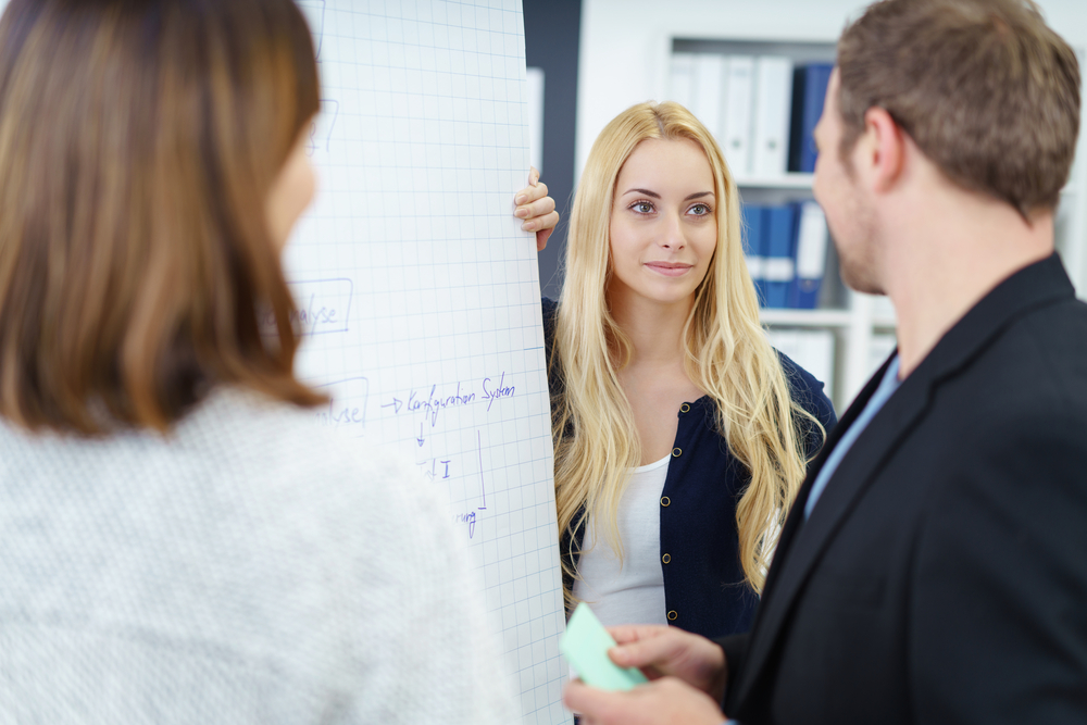 BusinessTeamWorkingTogetherOnAProjectStandingGroupedTogether - welltica.dk - Vejen til et bedre liv