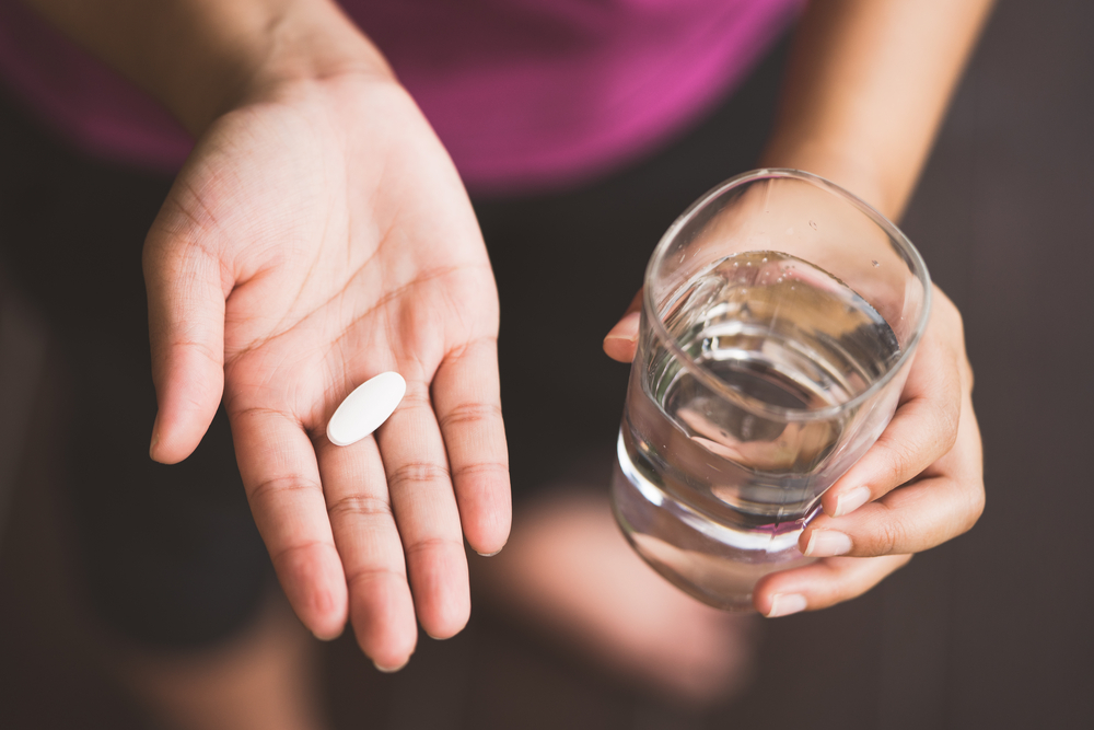 CloseUpOfGirlHoldingPillAndGlassOfWaterwith - welltica.dk - Vejen til et bedre liv