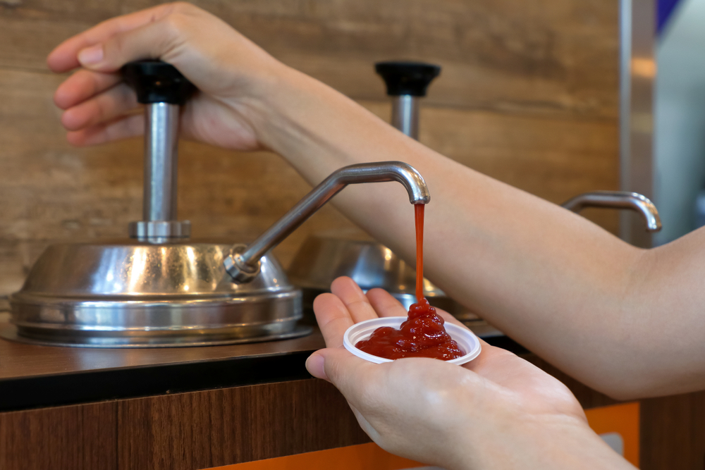 HandPumpingKetchupFromSaucePumpInToSmallPlastic - welltica.dk - Vejen til et bedre liv