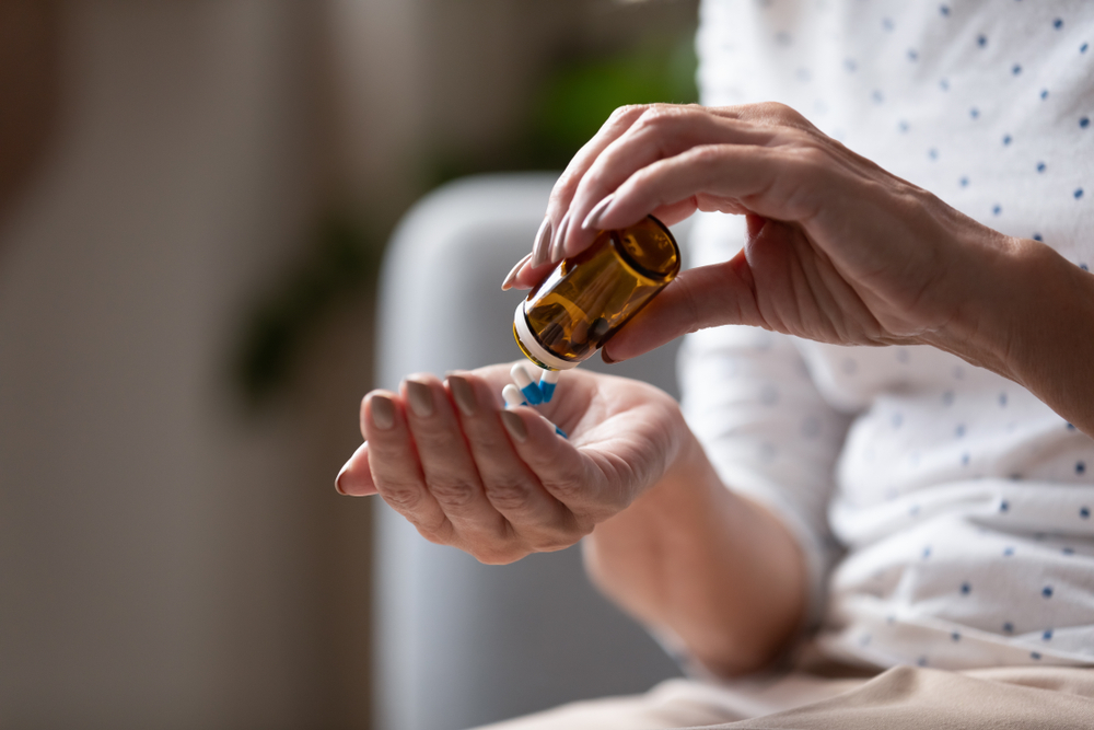 CloseUpMatureWomanTakingOutPillsFromBottleSupplements - welltica.dk - Vejen til et bedre liv