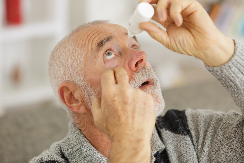 SeniorManDrippingARedEyeWithEyeDrops - welltica.dk - Vejen til et bedre liv