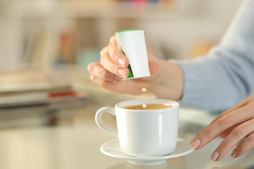 CloseUpOfWomanHandThrowingSaccharinPillsOnCoffee - welltica.dk - Vejen til et bedre liv