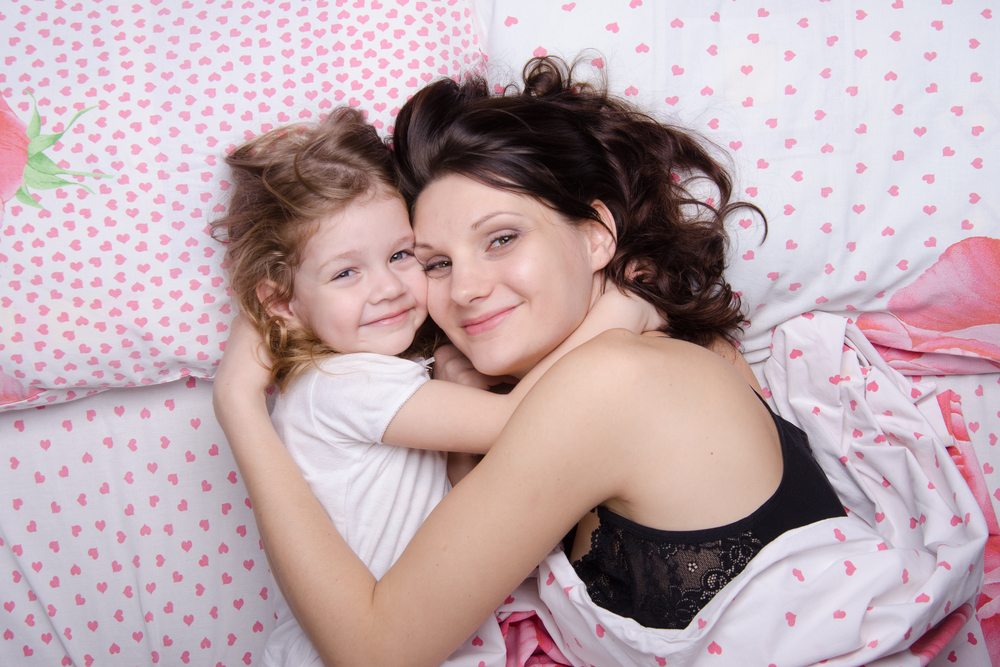 MomAndDaughterWithAnExcellentMoodLieInBed - welltica.dk - Vejen til et bedre liv