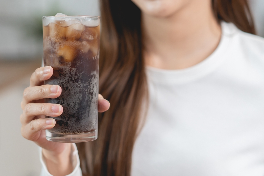 PersonHoldingAGlassOfSodaCola - welltica.dk - Vejen til et bedre liv