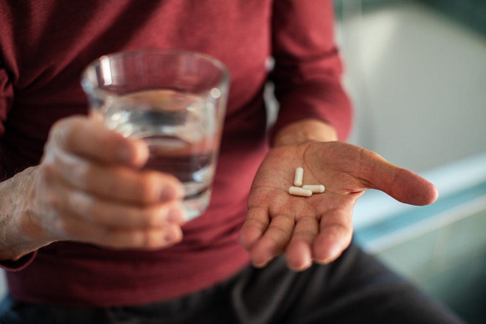 ElderlyManTakingMedicationInBathroom - welltica.dk - Vejen til et bedre liv