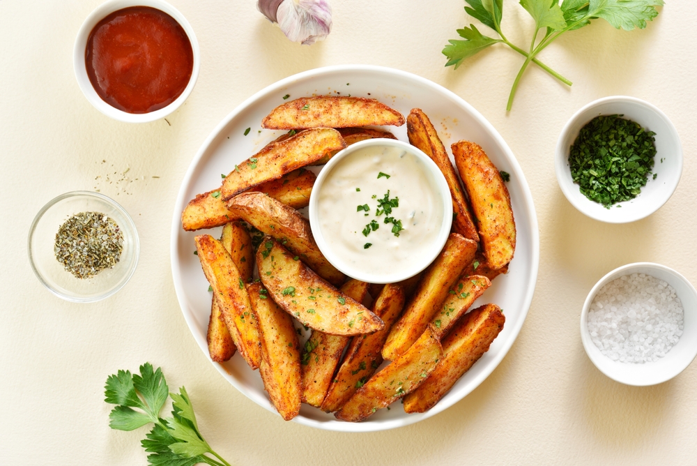 OvenBakedPotatoWedgesWithSauceOverLightStoneBackground - welltica.dk - Vejen til et bedre liv