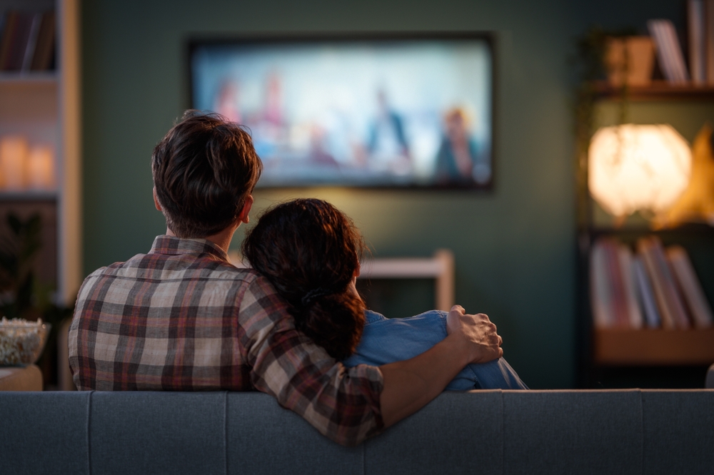 HappyFamilyWatchingTvMoviesInTheEveningAtHome - welltica.dk - Vejen til et bedre liv