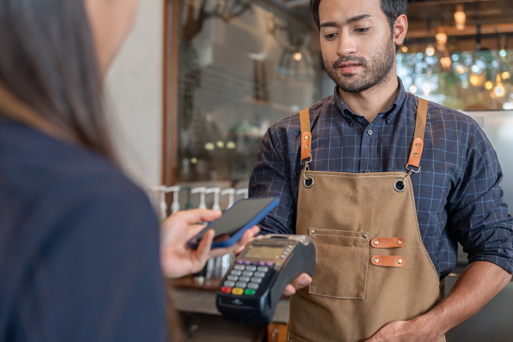 WomanUseSmartphoneToScanQrCodeToPayIn - welltica.dk - Vejen til et bedre liv