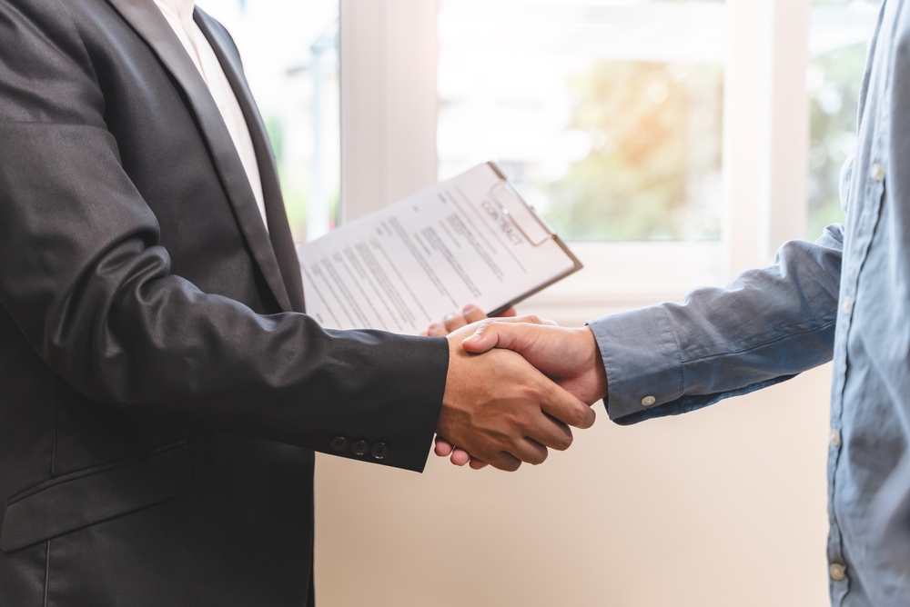 ClientAndBankerShakingHandAfterLeaseContractSuccessful - welltica.dk - Vejen til et bedre liv
