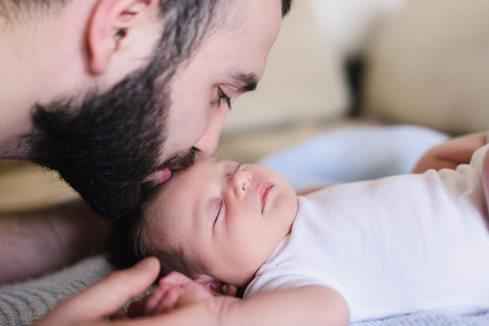 AYoungFatherKissesHisSleepingNewbornSonFatherAnd - welltica.dk - Vejen til et bedre liv