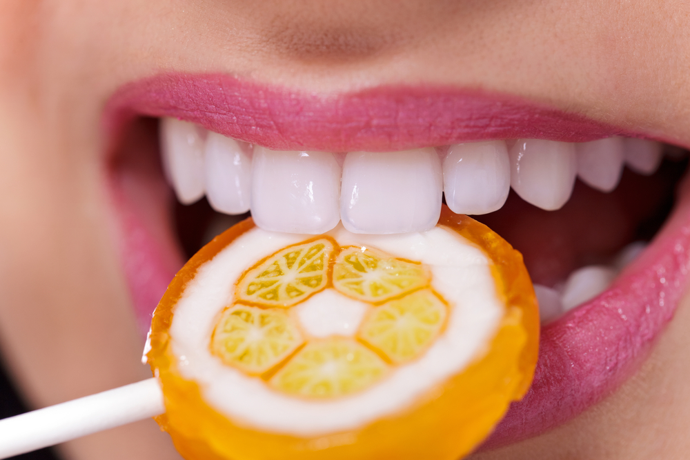 CloseUpOfMouthWithPerfectTeethAndLollipop - welltica.dk - Vejen til et bedre liv