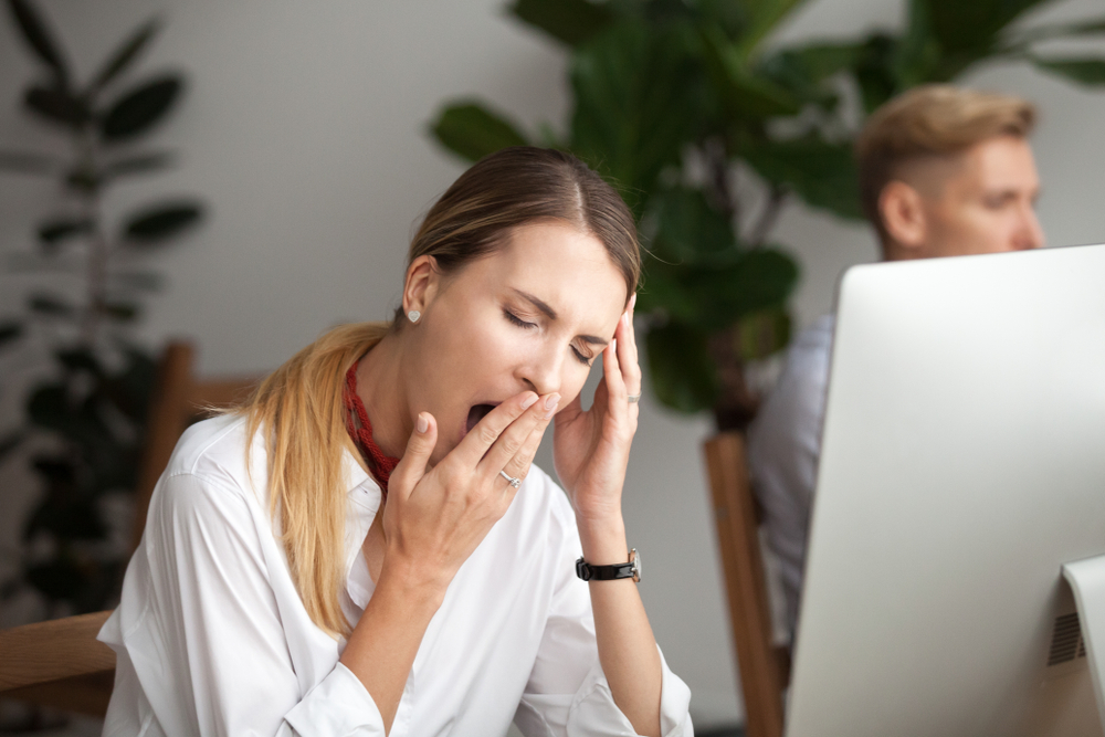 BoredBusinesswomanYawningAtWorkplaceFeelingNoMotivationOrLack - welltica.dk - Vejen til et bedre liv