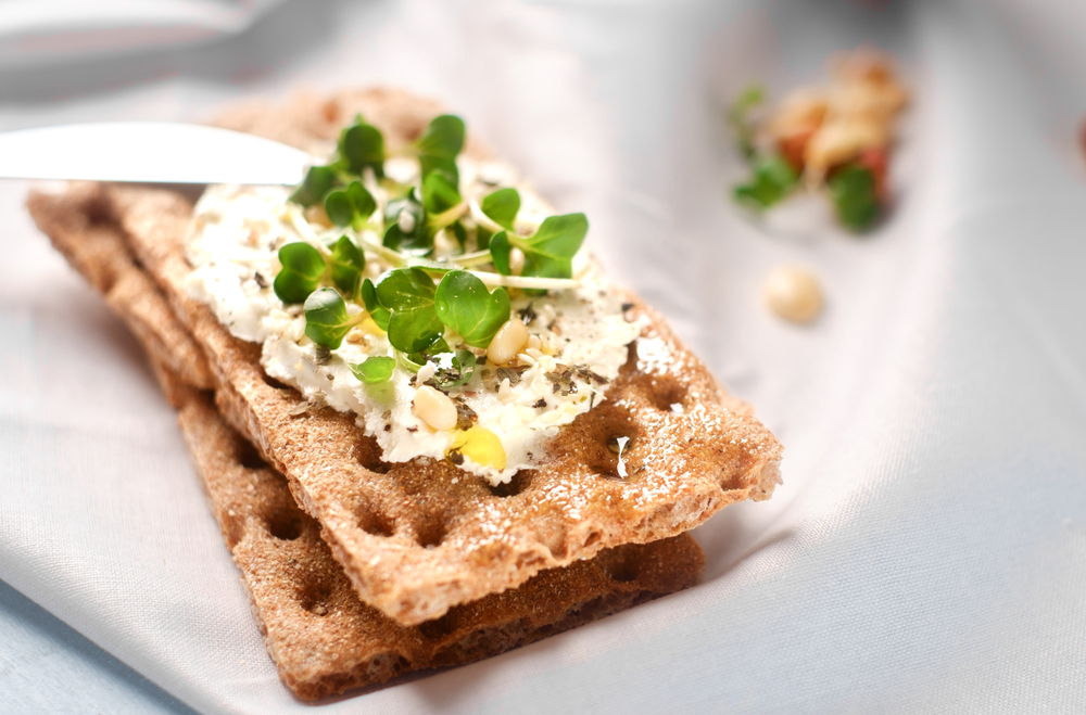 CrispbreadWithCreamCheeseAndFreshHerbsOnAWooden - welltica.dk - Vejen til et bedre liv