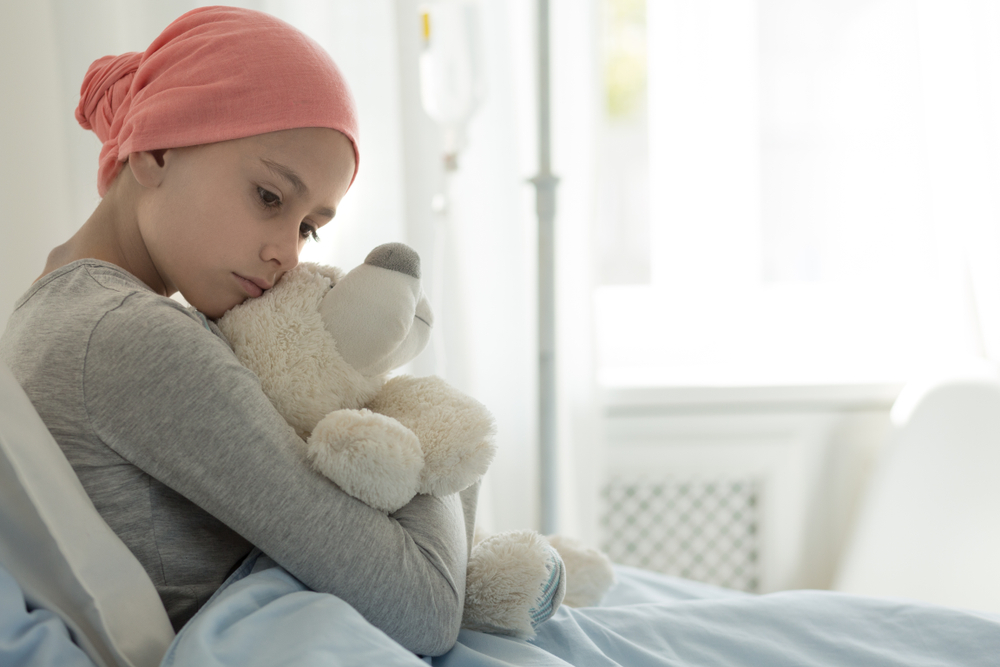 WeakGirlWithCancerWearingPinkHeadscarfAndHuggingTeddy - welltica.dk - Vejen til et bedre liv