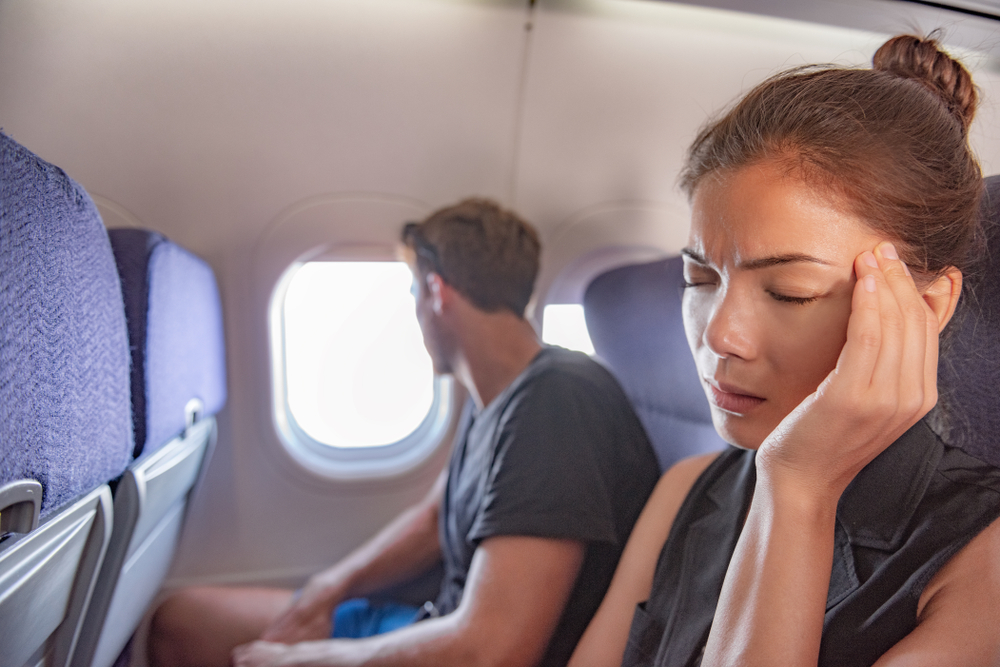 SickWomanInAirplaneFearOfFlyingInsidePlaneCabin - welltica.dk - Vejen til et bedre liv