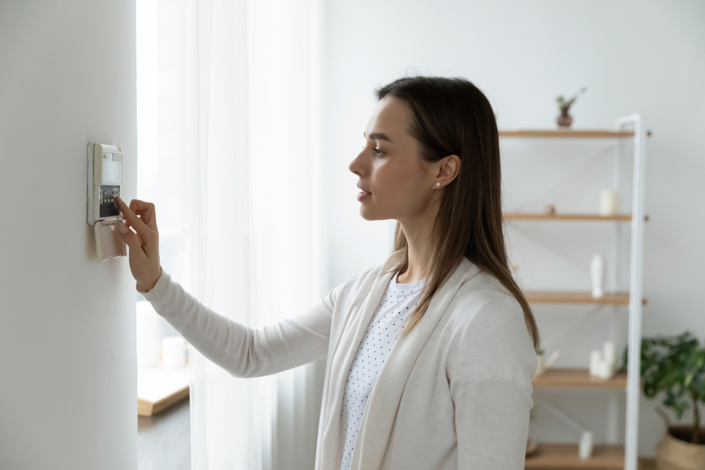 SideViewPleasantYoungWomanUsingSmartHomeSystemOr - welltica.dk - Vejen til et bedre liv