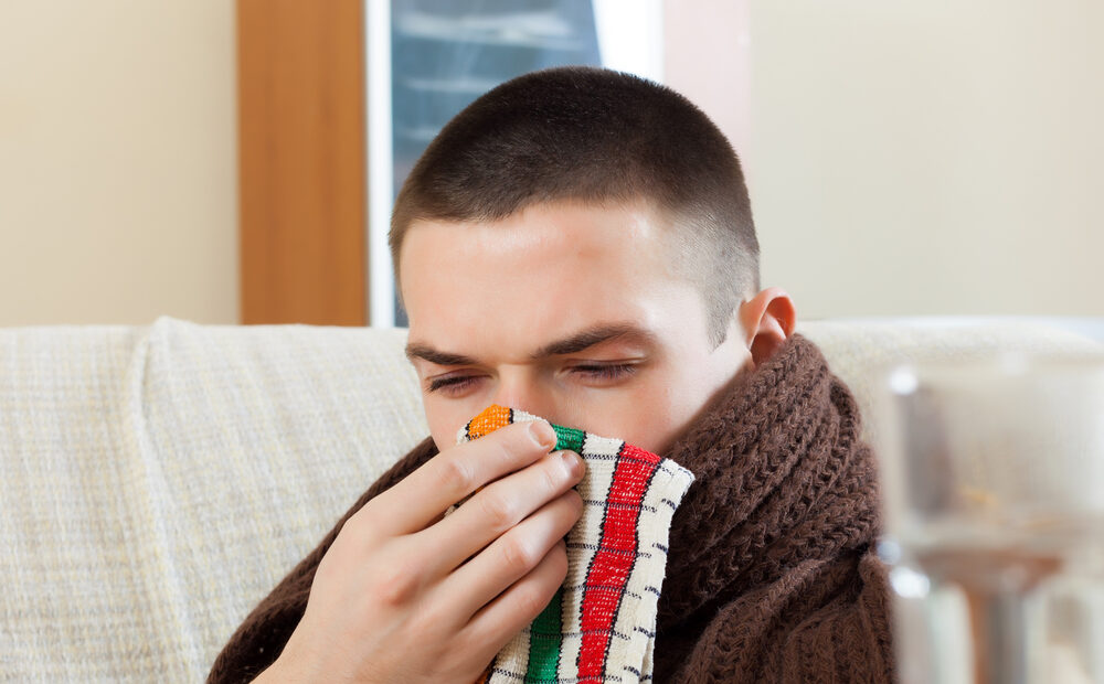 OrdinarySickManInPlaidUsesHandkerchiefInHome - welltica.dk - Vejen til et bedre liv