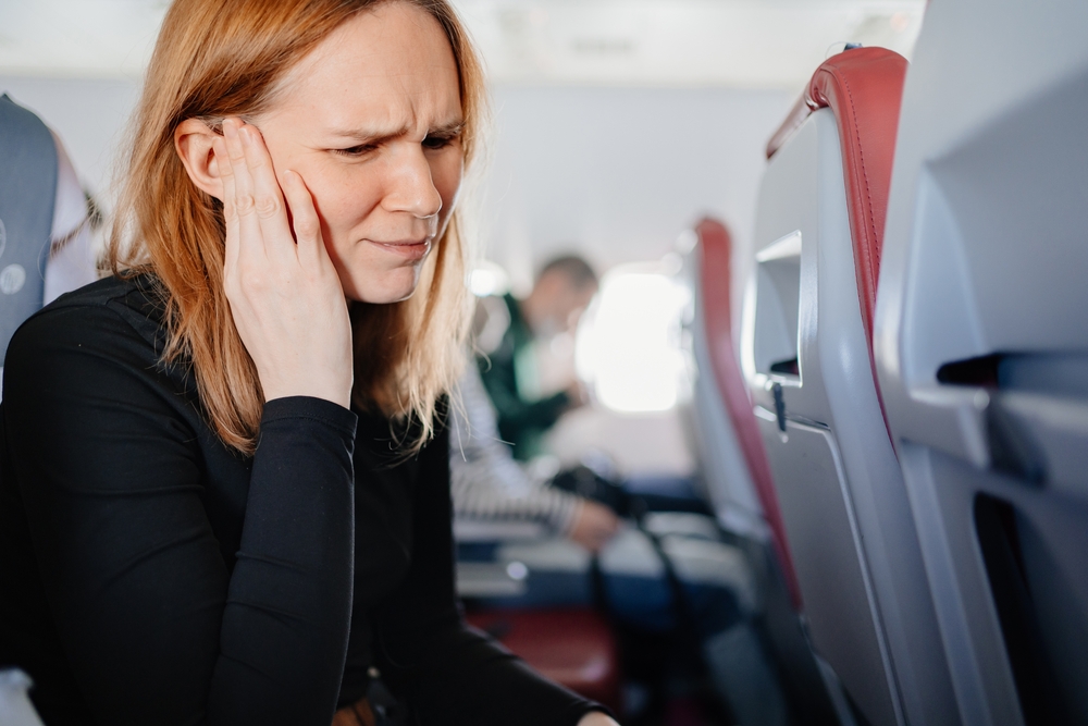 AWomanSittingOnAnAirplaneHasAHeadacheAnd - welltica.dk - Vejen til et bedre liv
