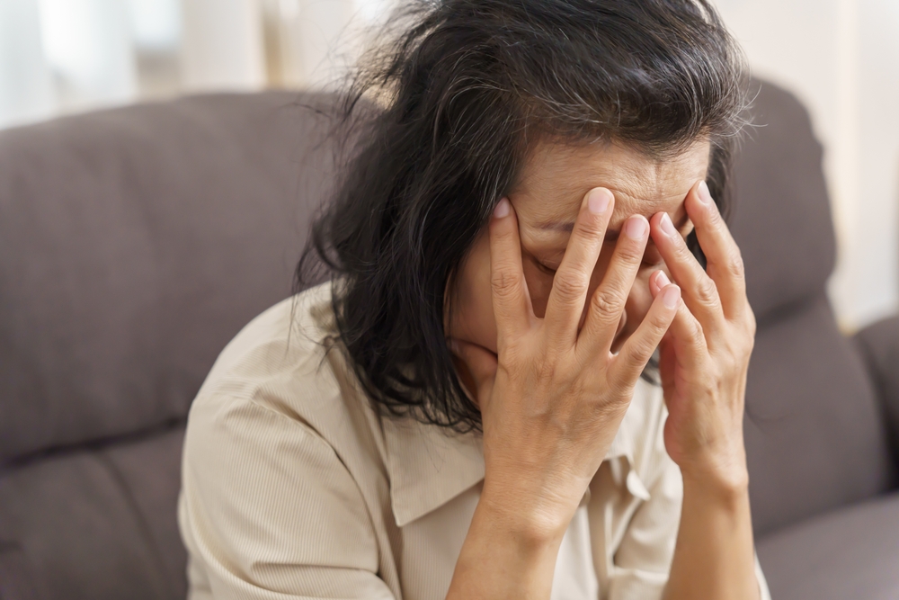 SadMiddleAgeAsianWomanTouchingForeheadHavingHeadacheSuffering - welltica.dk - Vejen til et bedre liv