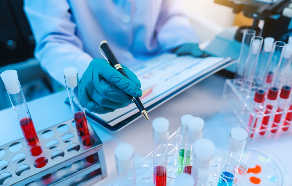 AsianPeopleScientistInLabCoatAndProtectiveGlovesWorking - welltica.dk - Vejen til et bedre liv