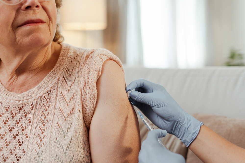 DoctorVaccinatingASeniorWomanAtHomeEnsuringHerWell-being - welltica.dk - Vejen til et bedre liv