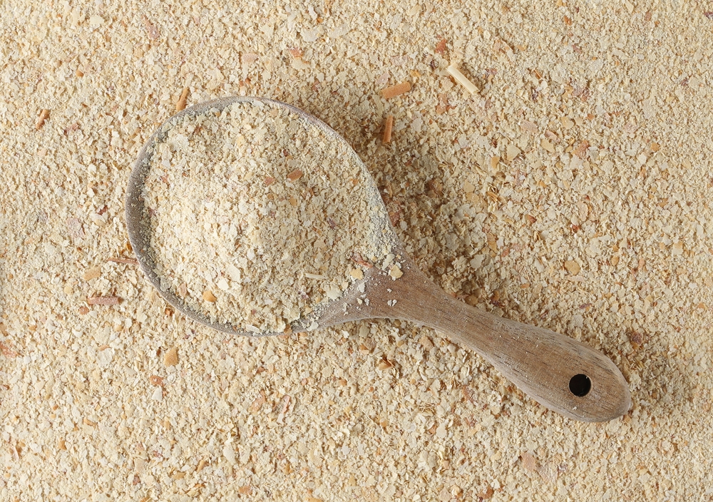 NutritionalYeastPileInWoodenSpoondeactivatedYeastBackgroundTop - welltica.dk - Vejen til et bedre liv