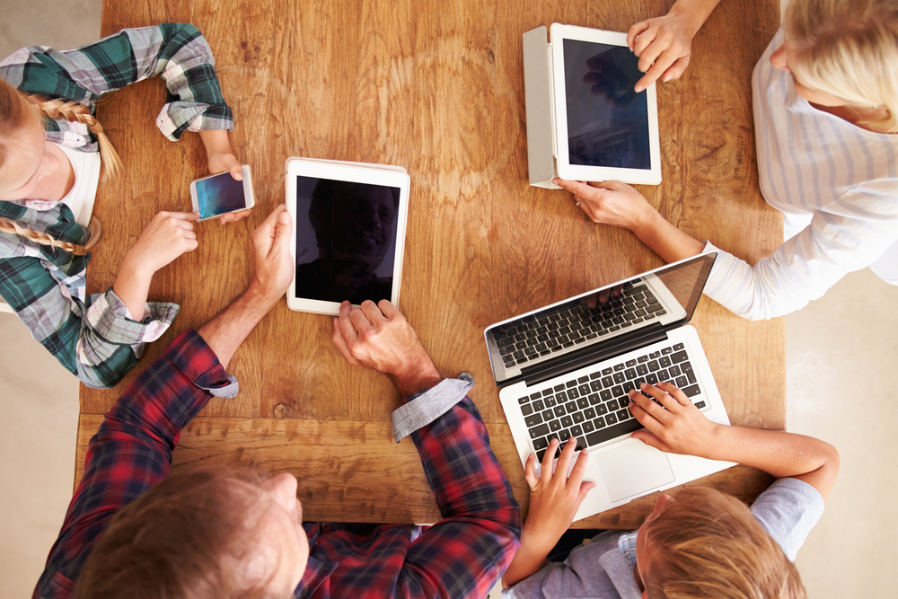 FamilyUsingNewTechnologyOverheadView - welltica.dk - Vejen til et bedre liv