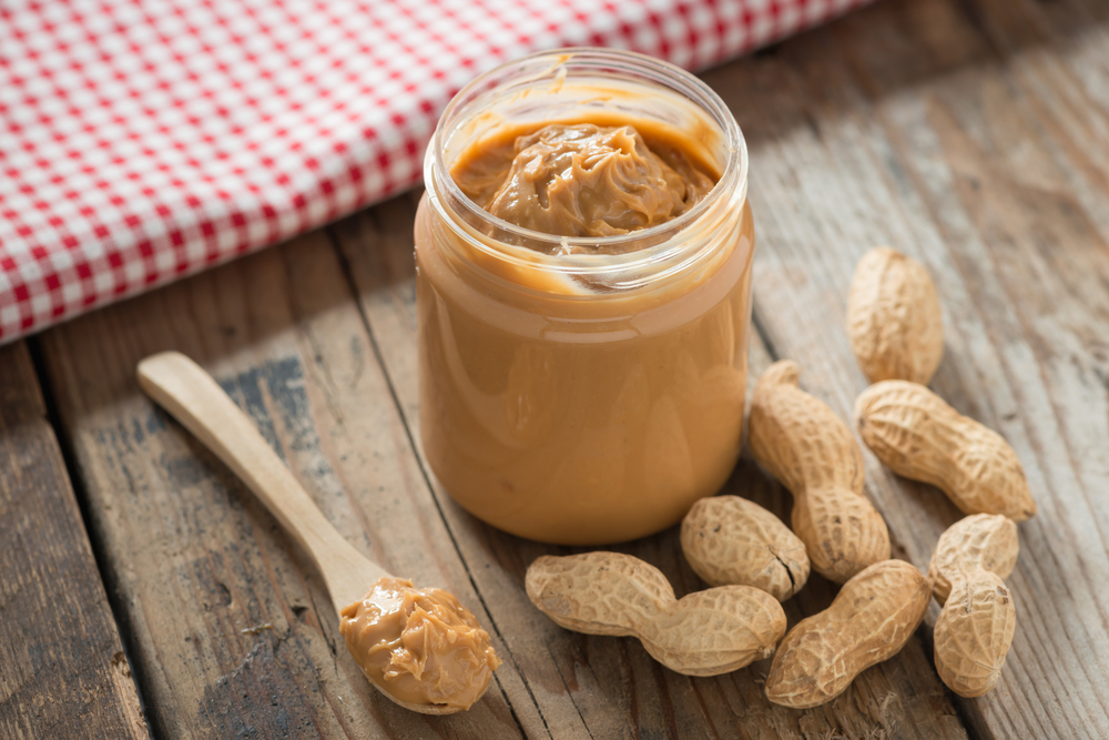 CreamyAndSmoothPeanutButterInJarOnWoodTable - welltica.dk - Vejen til et bedre liv