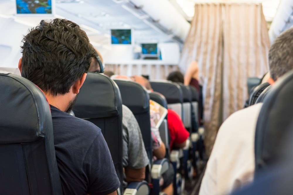 AirplaneInteriorPassangerLookingDownTheAisle - welltica.dk - Vejen til et bedre liv