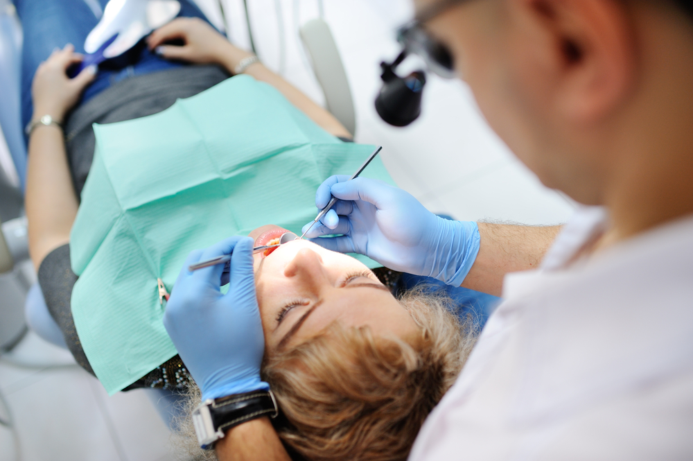 MaleDentistExaminesTheMouthAndTeethOfAPatient - welltica.dk - Vejen til et bedre liv