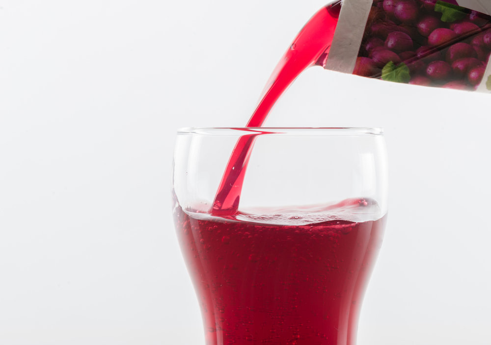 DrinkPouringPurpleGrapeJuiceIntoAGlassOn - welltica.dk - Vejen til et bedre liv