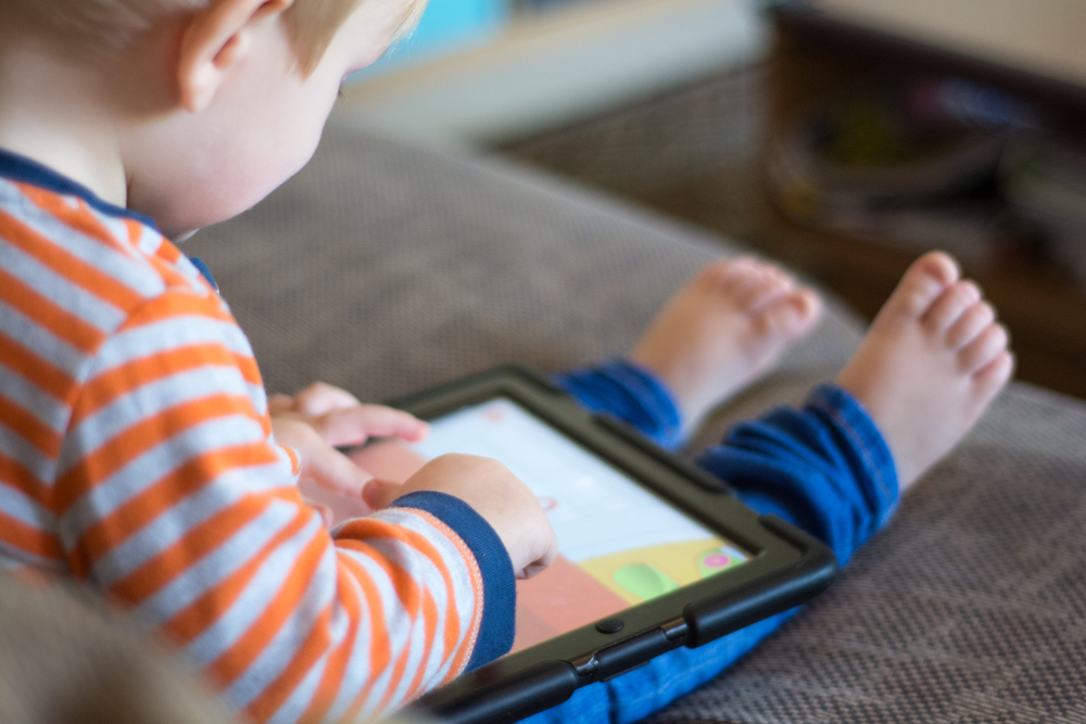 ChildUsingATouchScreenTabletToPlayLearningGame - welltica.dk - Vejen til et bedre liv