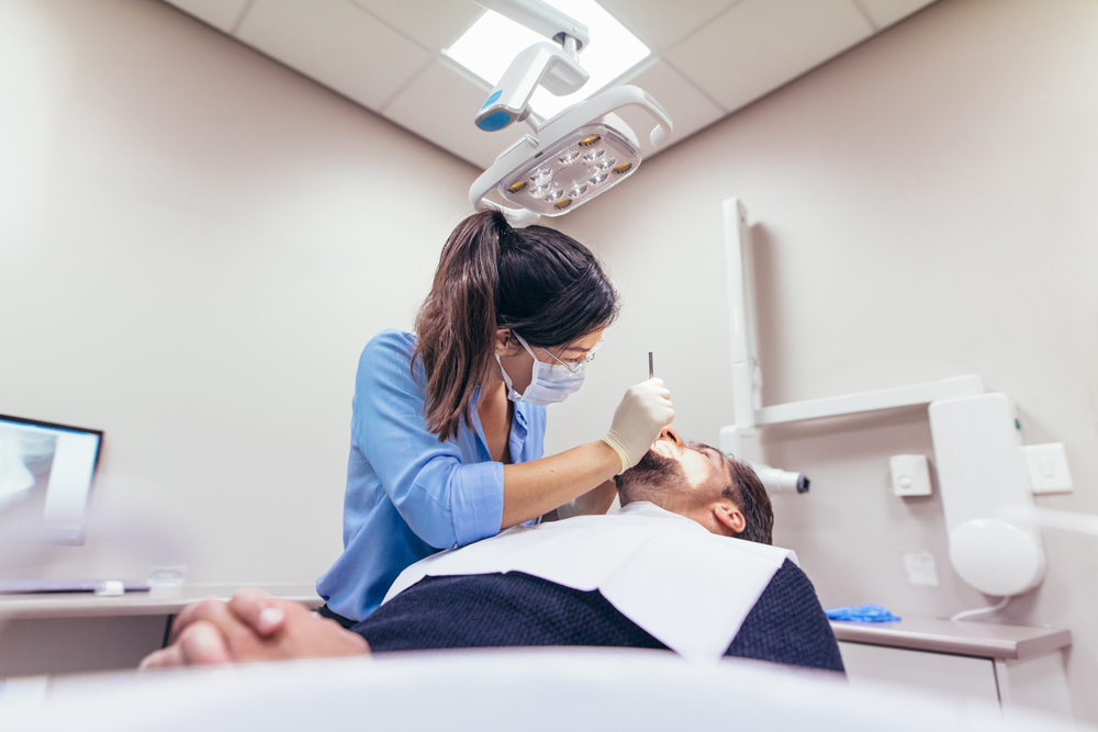 FemaleDentistExaminingAPatientWithToolsInDentalClinic - welltica.dk - Vejen til et bedre liv