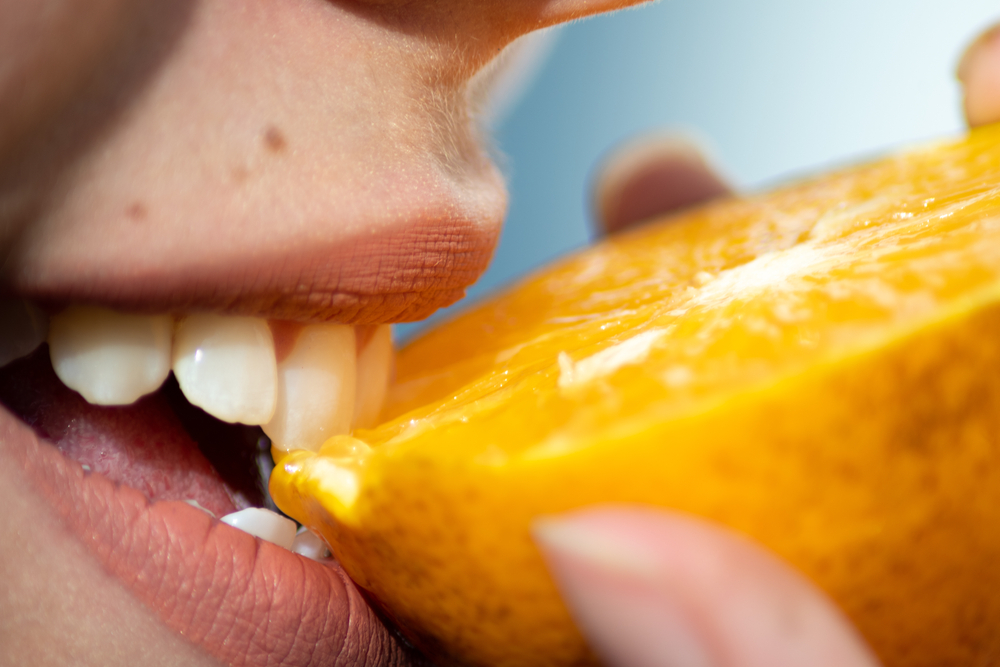 MacroPhotographyOfWomansWhiteTeethEatingHalfOrange - welltica.dk - Vejen til et bedre liv