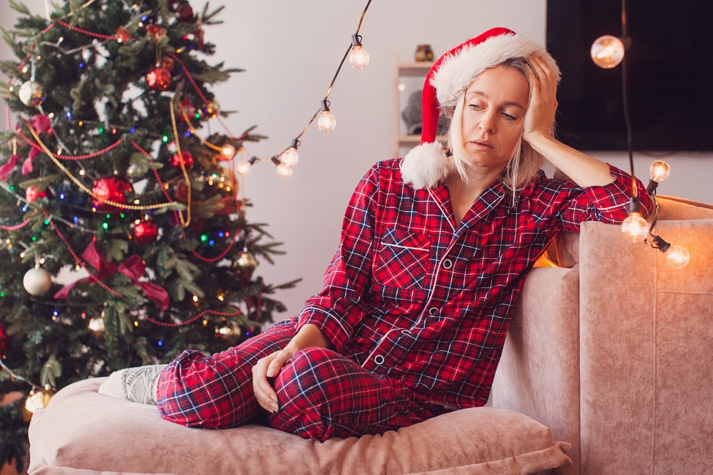SadWomanByTheChristmasTreeContemplatingStressedMiddleWoman - welltica.dk - Vejen til et bedre liv