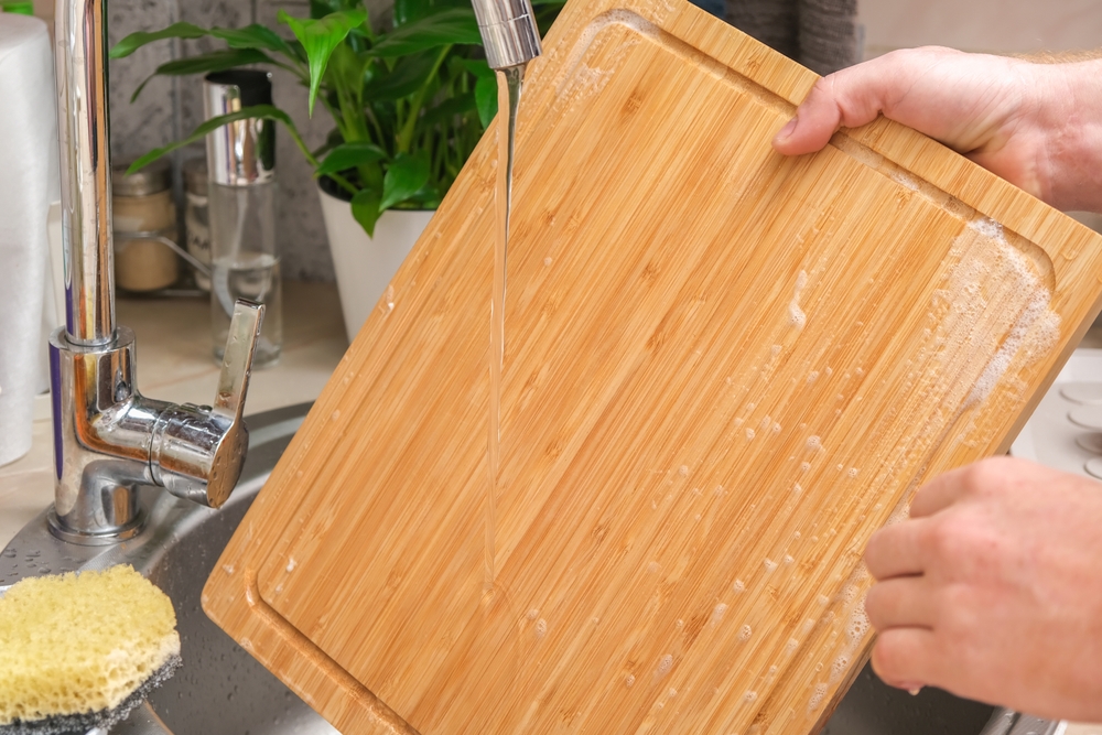 AManWashesAWoodenBambooCuttingBoardInThe - welltica.dk - Vejen til et bedre liv