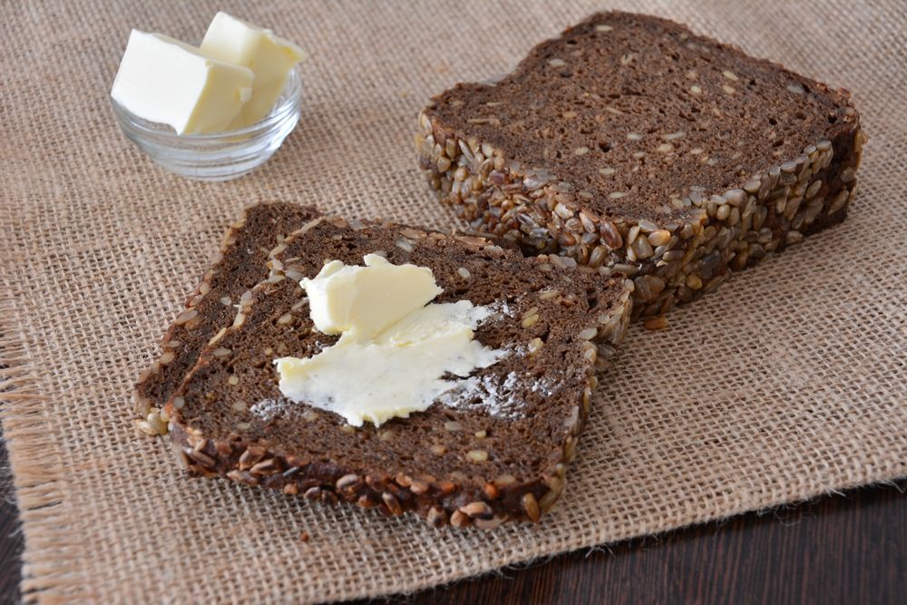 SlicesOfBreadWithButterOnARusticWoodenTable - welltica.dk - Vejen til et bedre liv